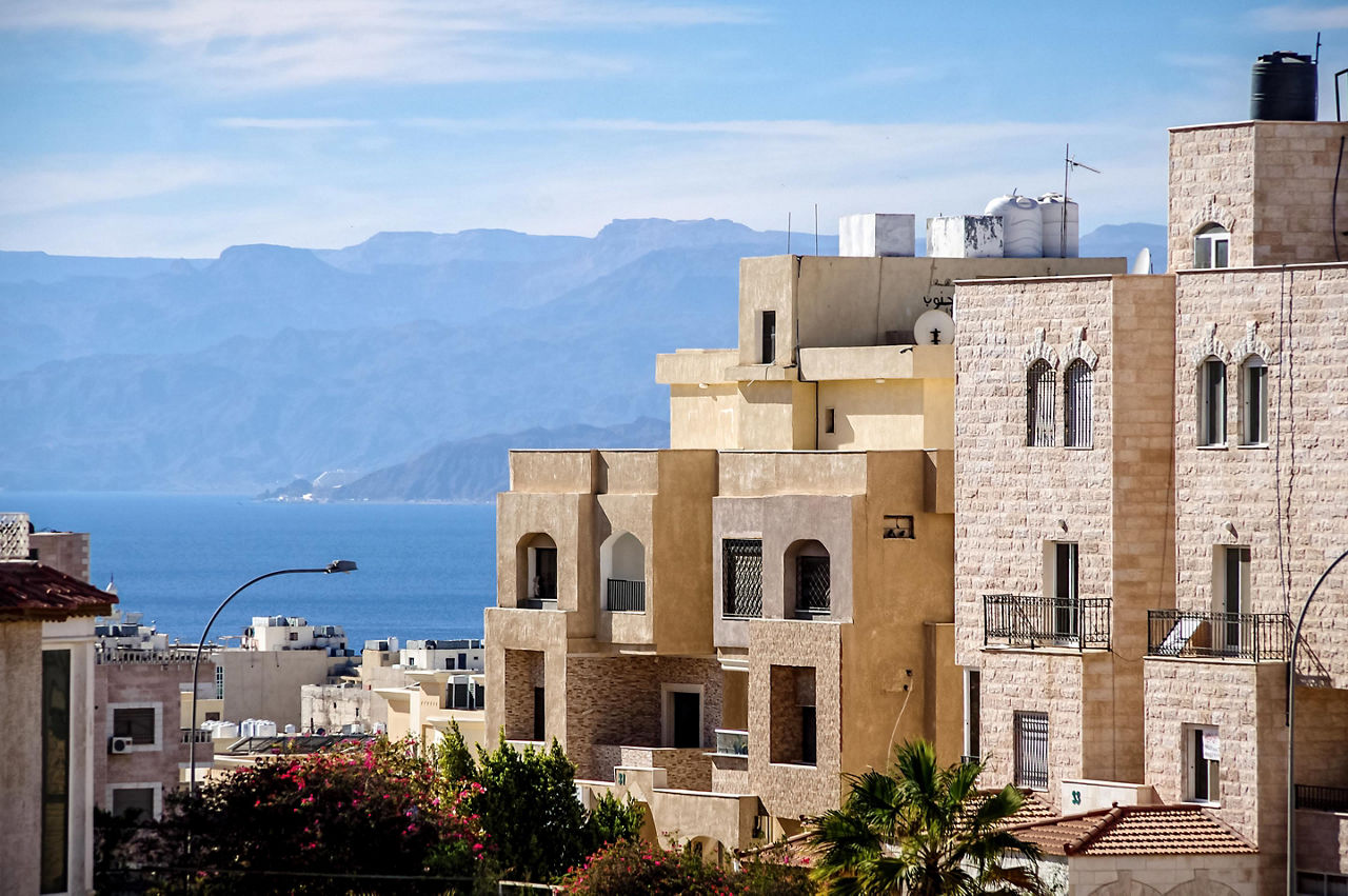 Typical Aqaba buildings on the foreground. the Gulf of Aqaba and mountains on the background
