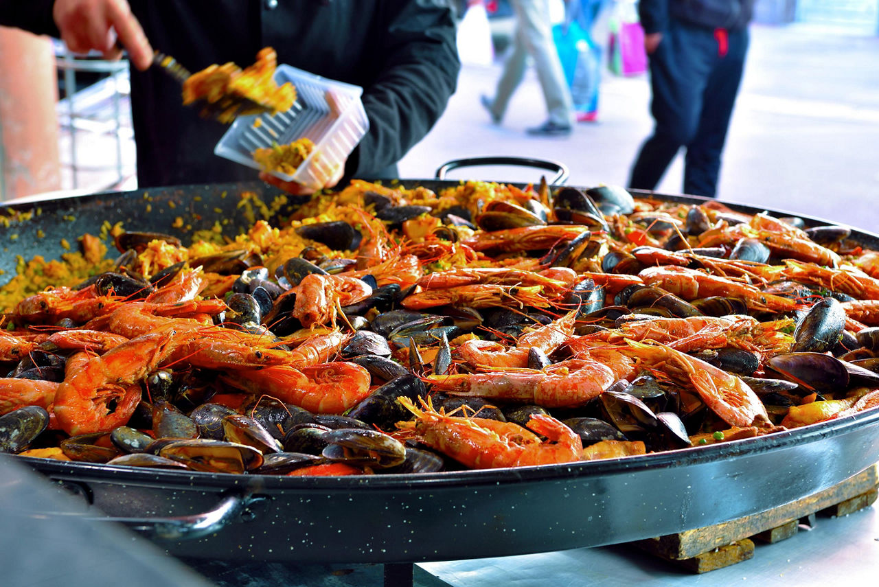 A chef serving paella at a local market in Cannes, France