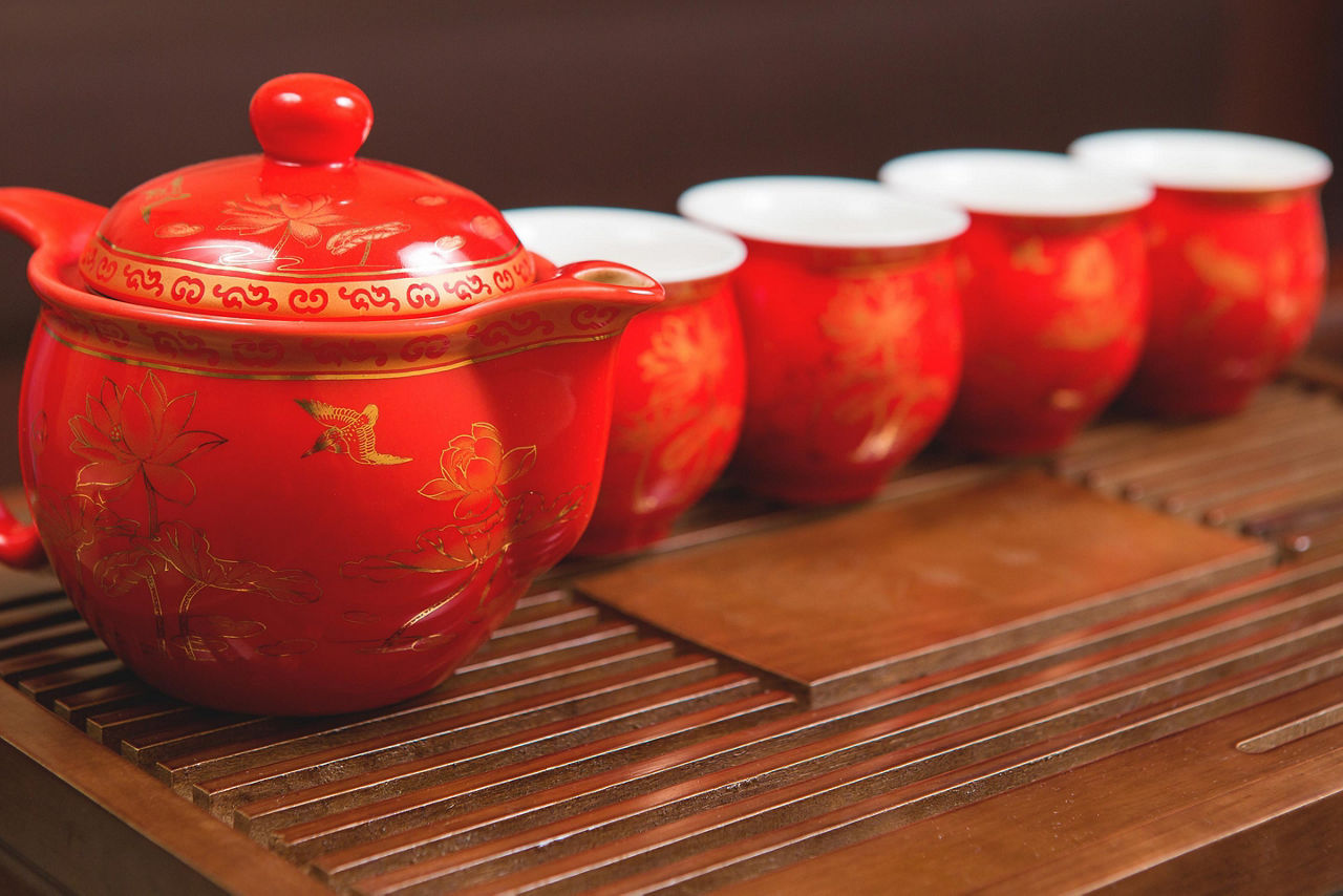 A red tea set with asian designs on a wooden platform in Taiwan