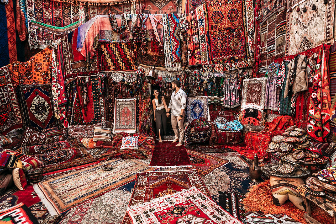Couple standing in a rug shop to haggle. World Cruise